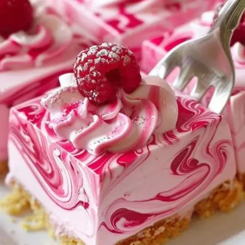 Creamy raspberry cheesecake slice with fresh raspberries on top