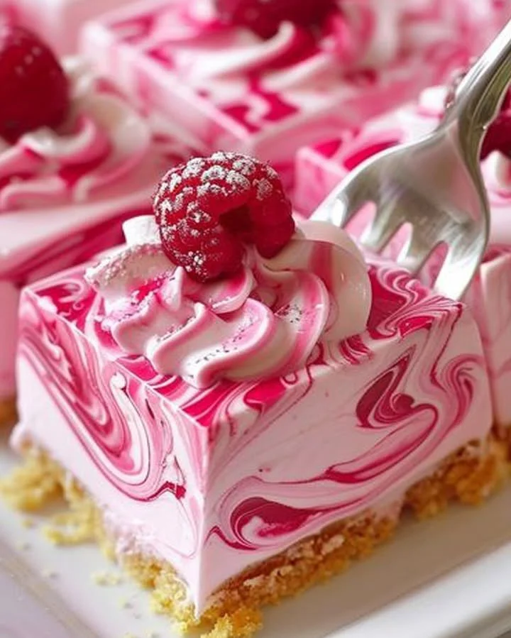 Creamy raspberry cheesecake slice with fresh raspberries on top