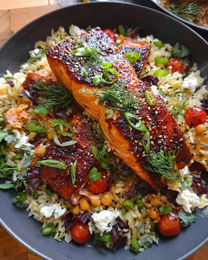 A delicious Salmon Rice Bowl garnished with fresh vegetables and sauces